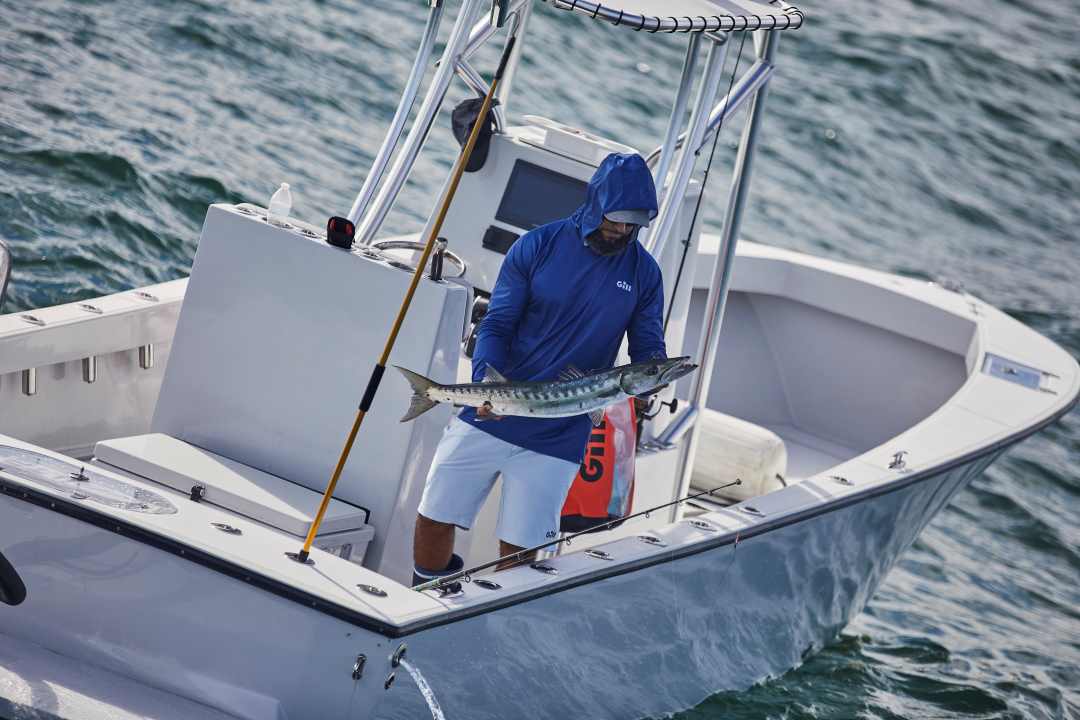 Person holding a fish on a boat in the water boating central