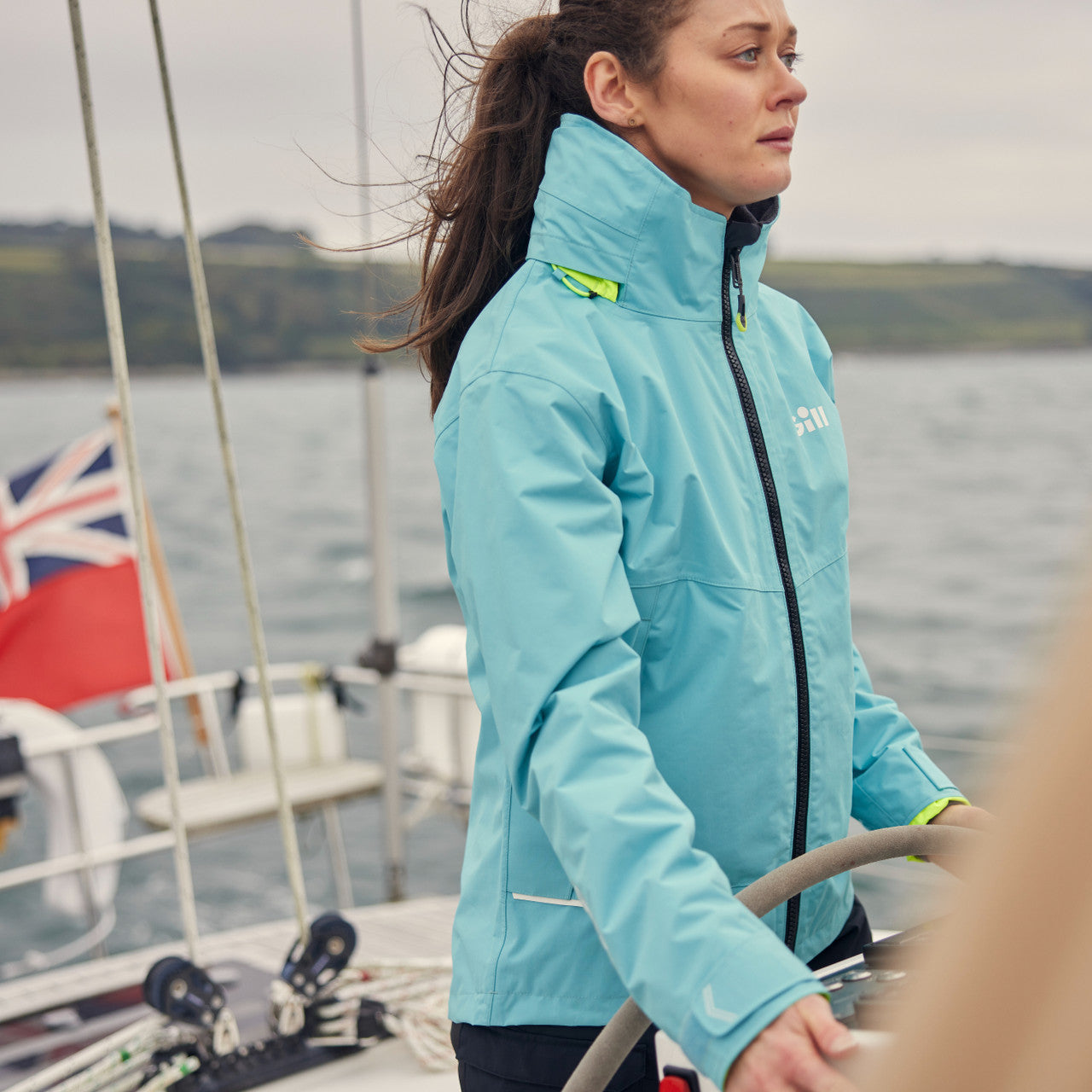 Person wearing a blue jacket on a boat with a scenic background boating central